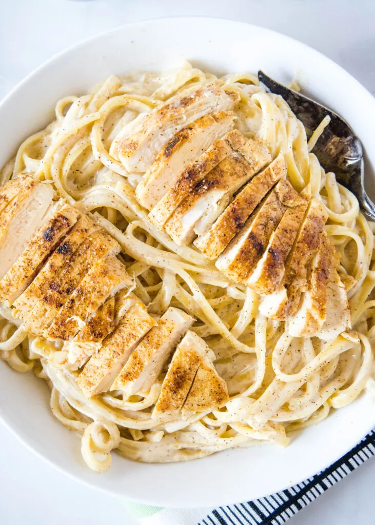 a large bowl of cajun alfredo with chicken on top