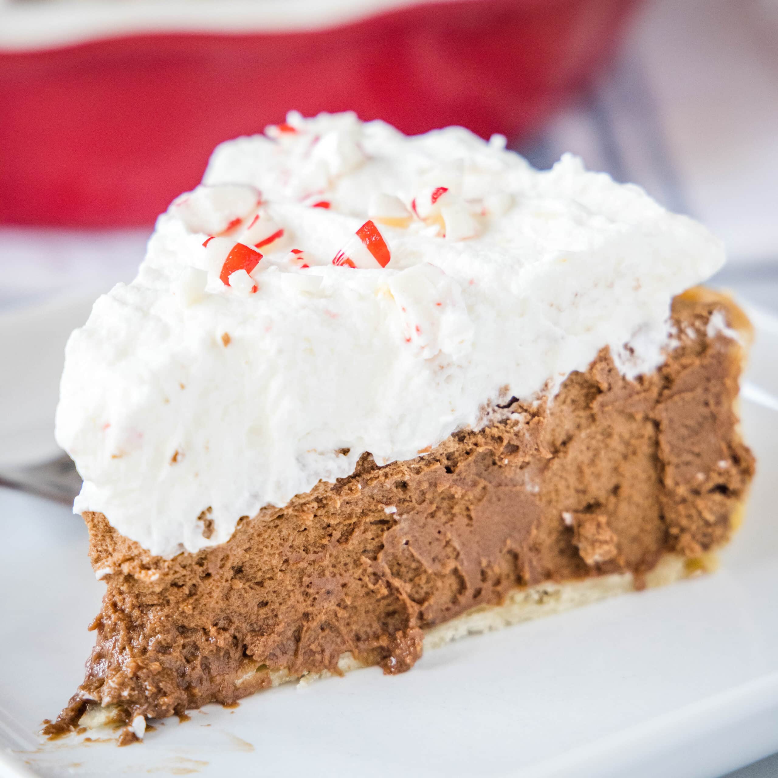 close up chocolate french silk pie with candy canes on a white plate