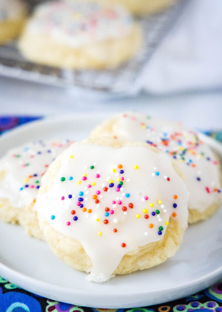 a white plate with sour cream sugar cookies arranged on it