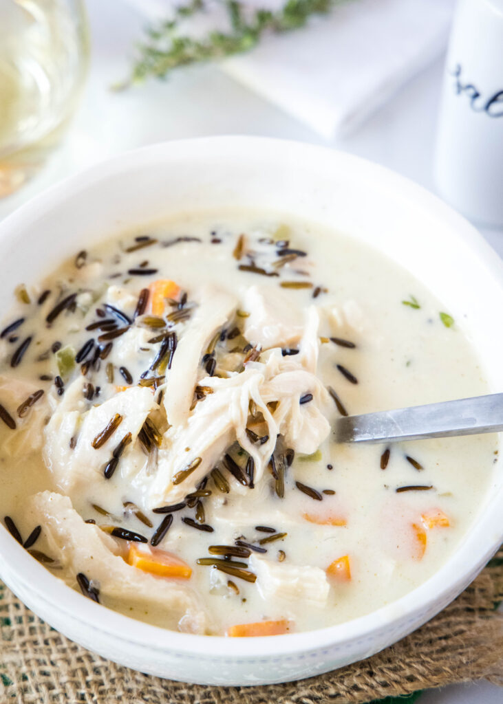 as spoon in a white bowl of turkey wild rice soup