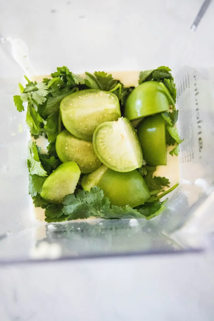 tomatillos and cilantro in a blender