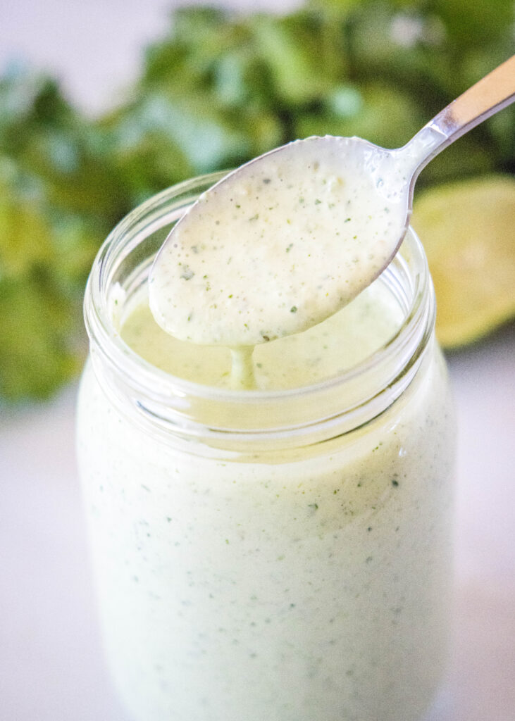 spooning tomatillo ranch dressing out of a jar