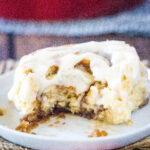 cropped square image of eggnog cinnamon roll on white plate