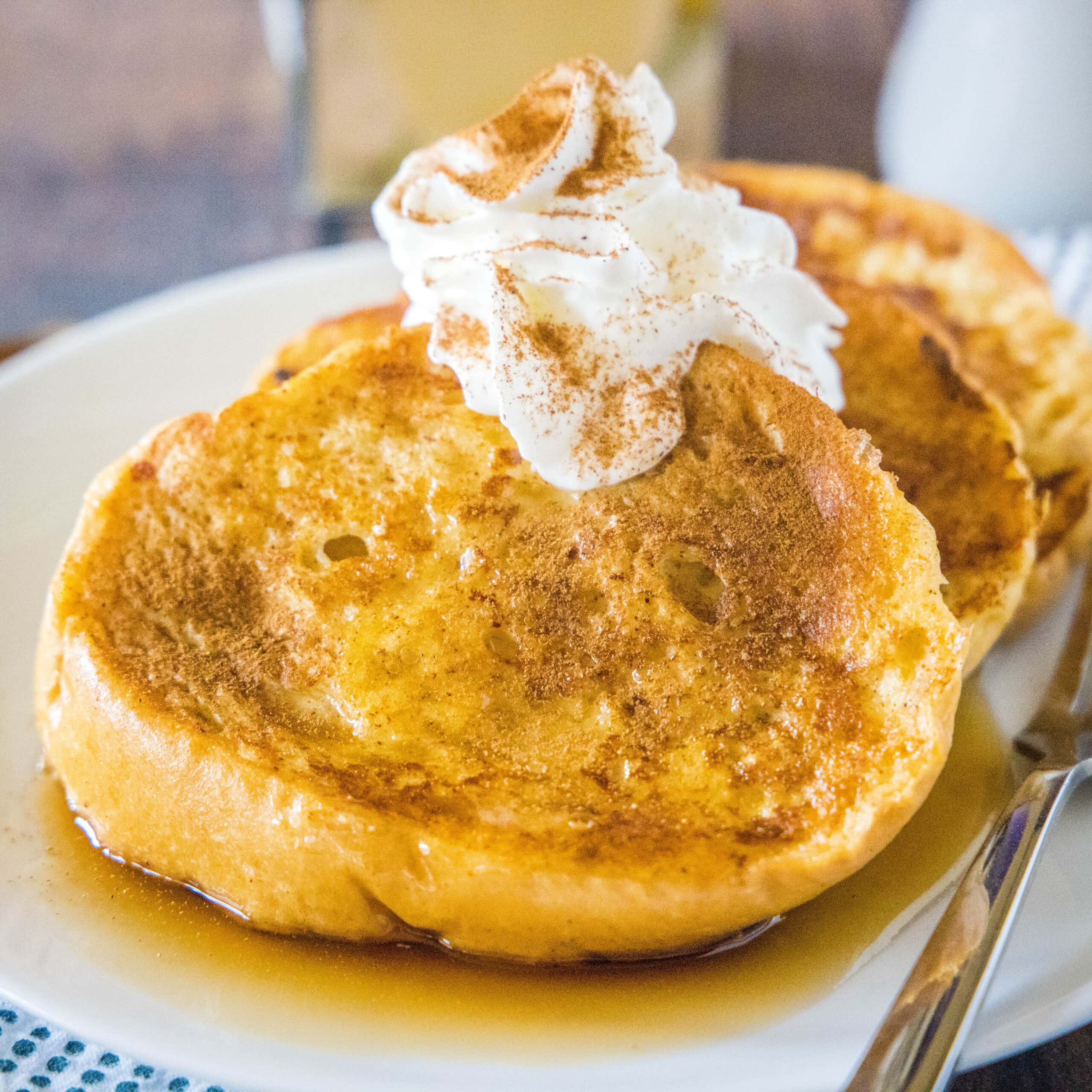 cropped plate of french toast with whipped cream and cinnamon on top