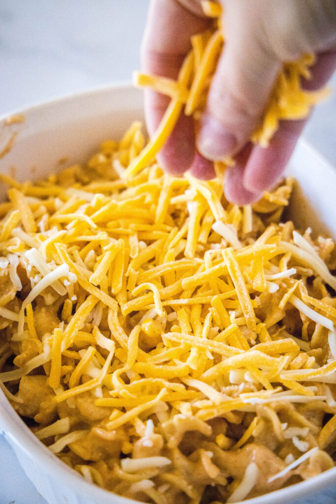 sprinkling cheese over a casserole dish