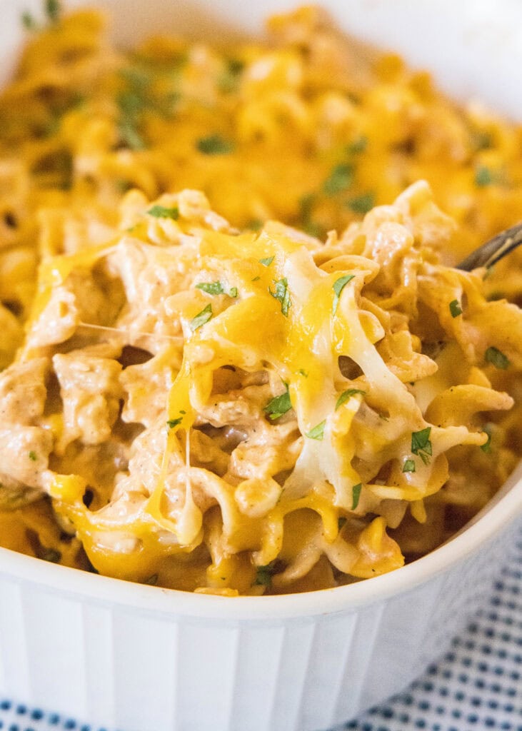 scooping enchilada casserole out of baking dish