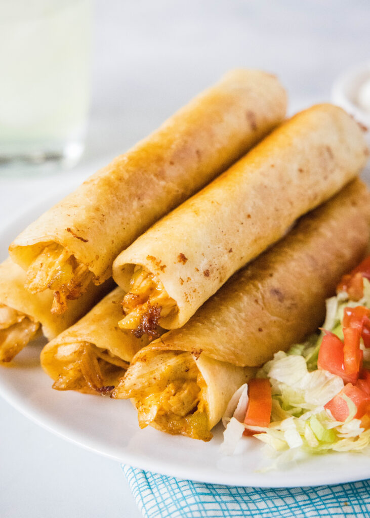 stack of flautas on a white plate
