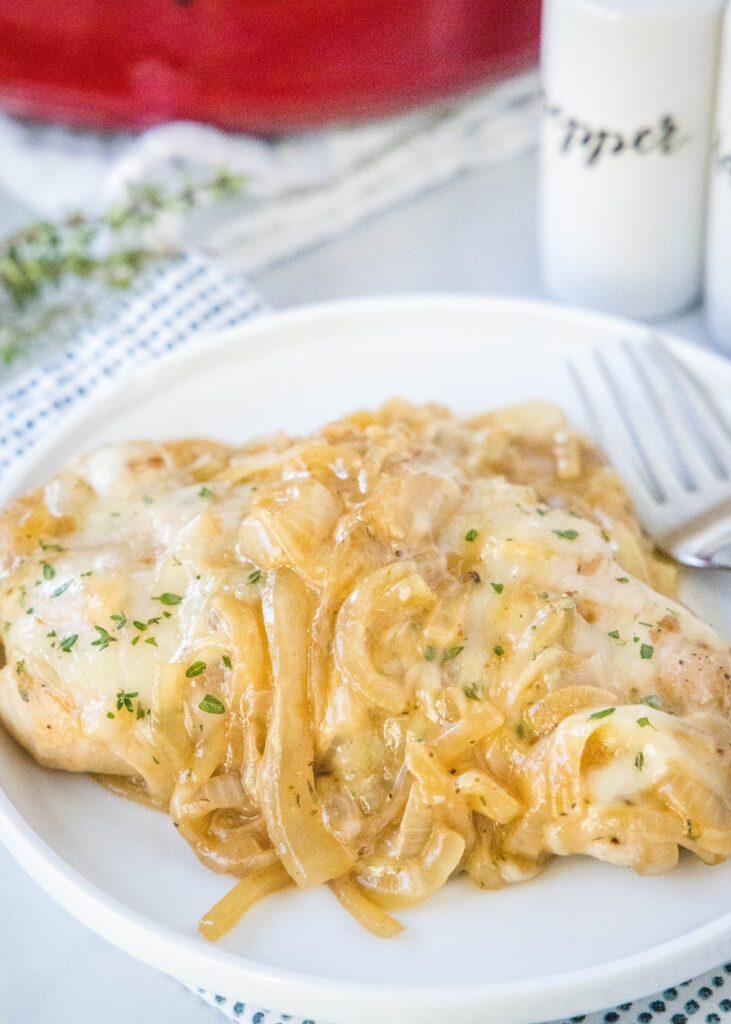 french onion pork chops on a plate with a fork