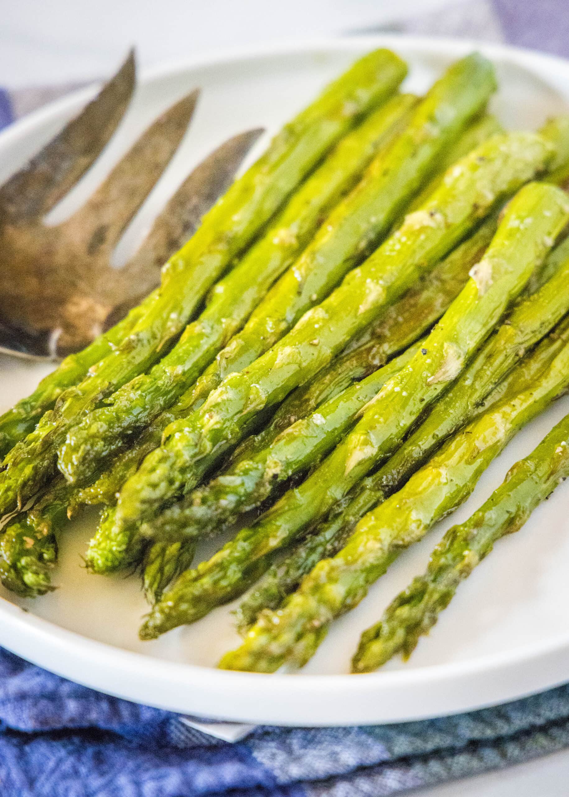 close up roasted asparagus on a white plate
