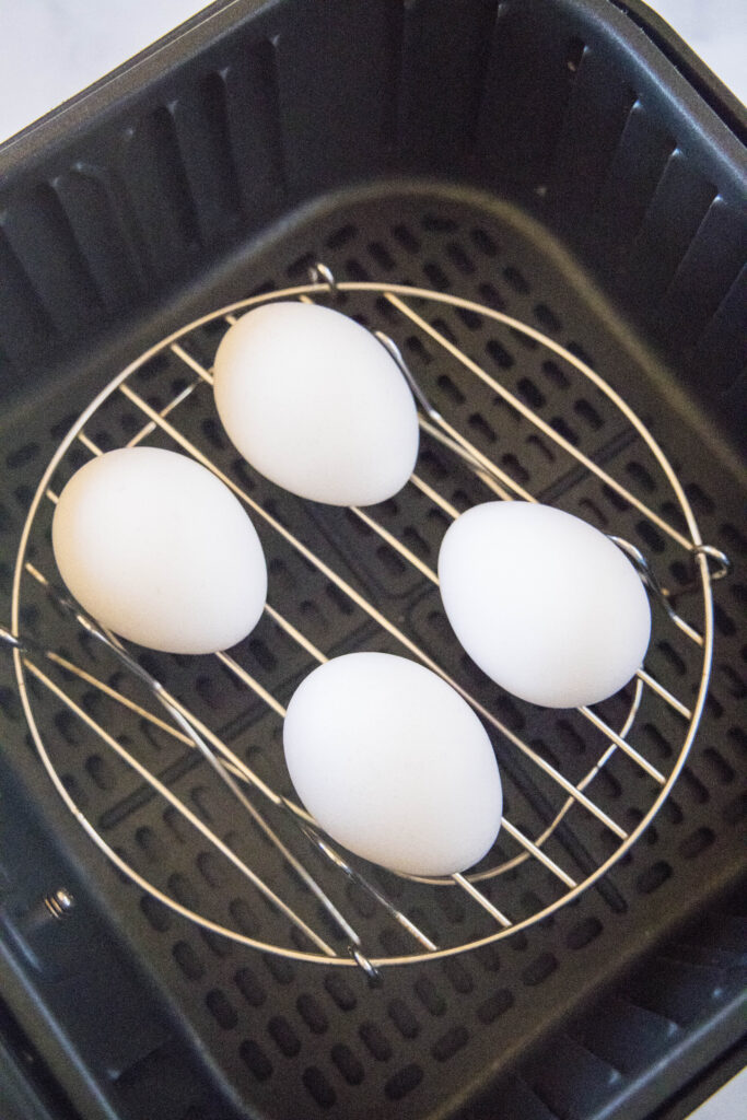 eggs on a metal trivet in the air fryer basket