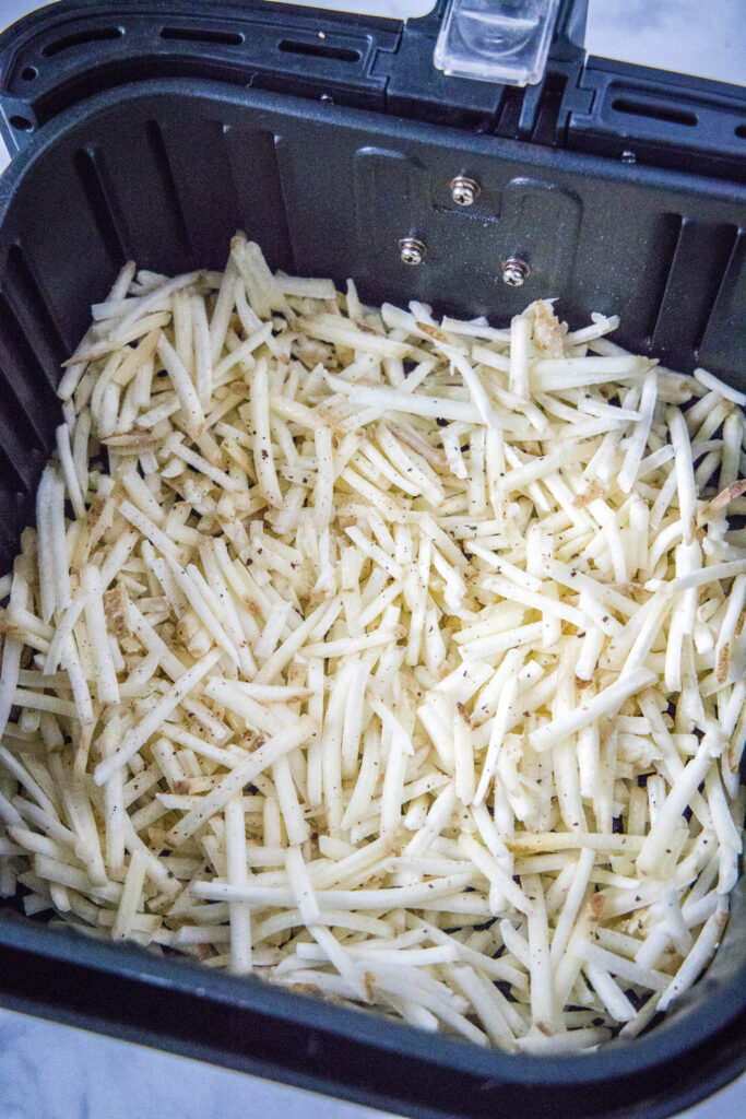 pommes de terre râpées dans le panier de la friteuse à air