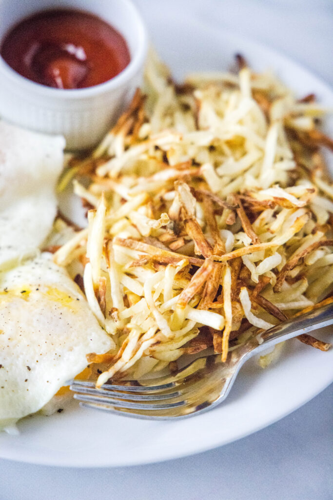 pommes de terre rissolées et œufs râpés sur une assiette