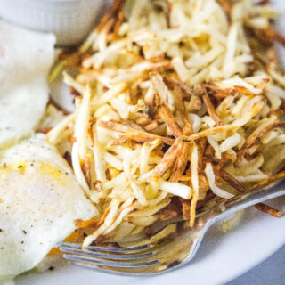 close up crispy air fryer hash browns on plate