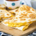 cropped close up of a sliced quesadilla on a cutting board
