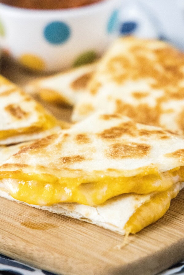 cropped close up of a sliced quesadilla on a cutting board