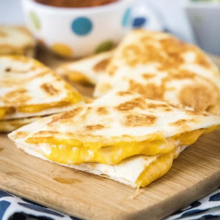 cropped close up of a sliced quesadilla on a cutting board