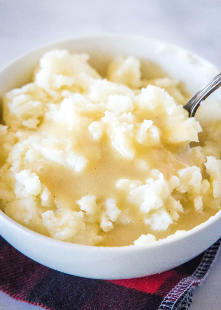 a spoon in a bowl of mashed potatoes