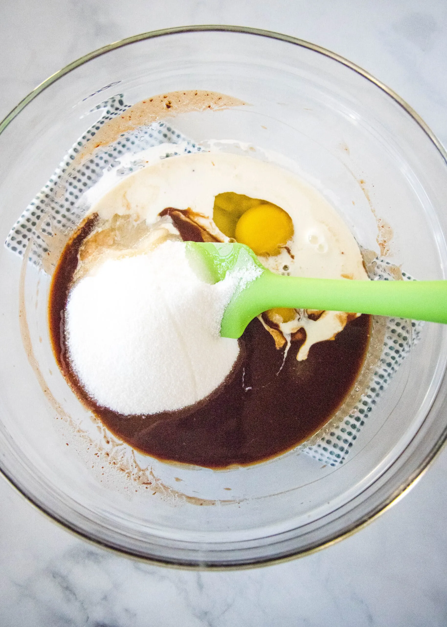 mixing sugar and eggs into melted chocolate