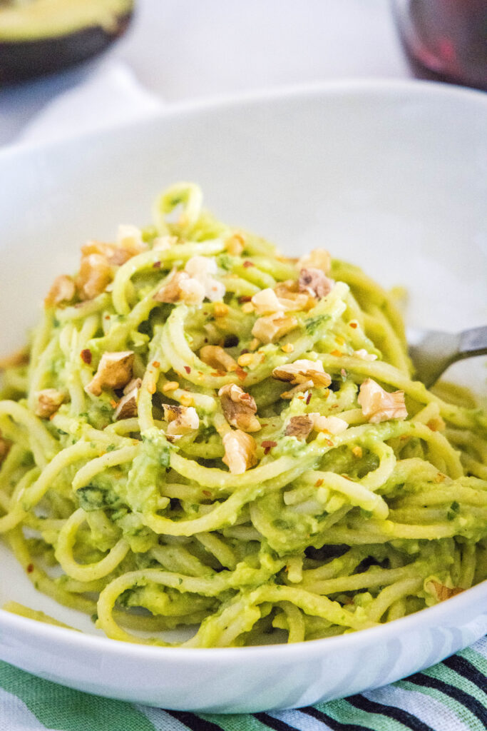 avocado pasta topped with nuts