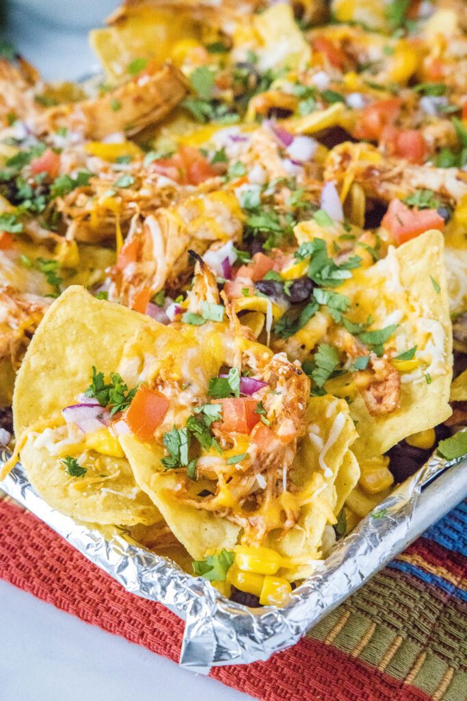 baked barbecue chicken nachos on a baking sheet