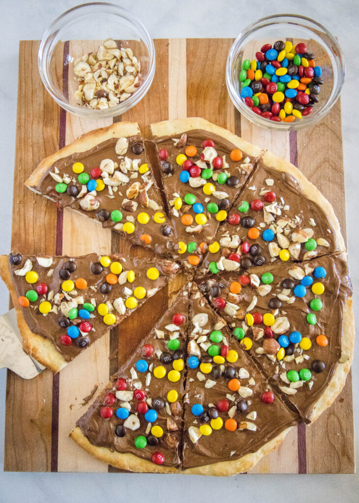 looking down on a cutting board with chocolate pizza cut into slices