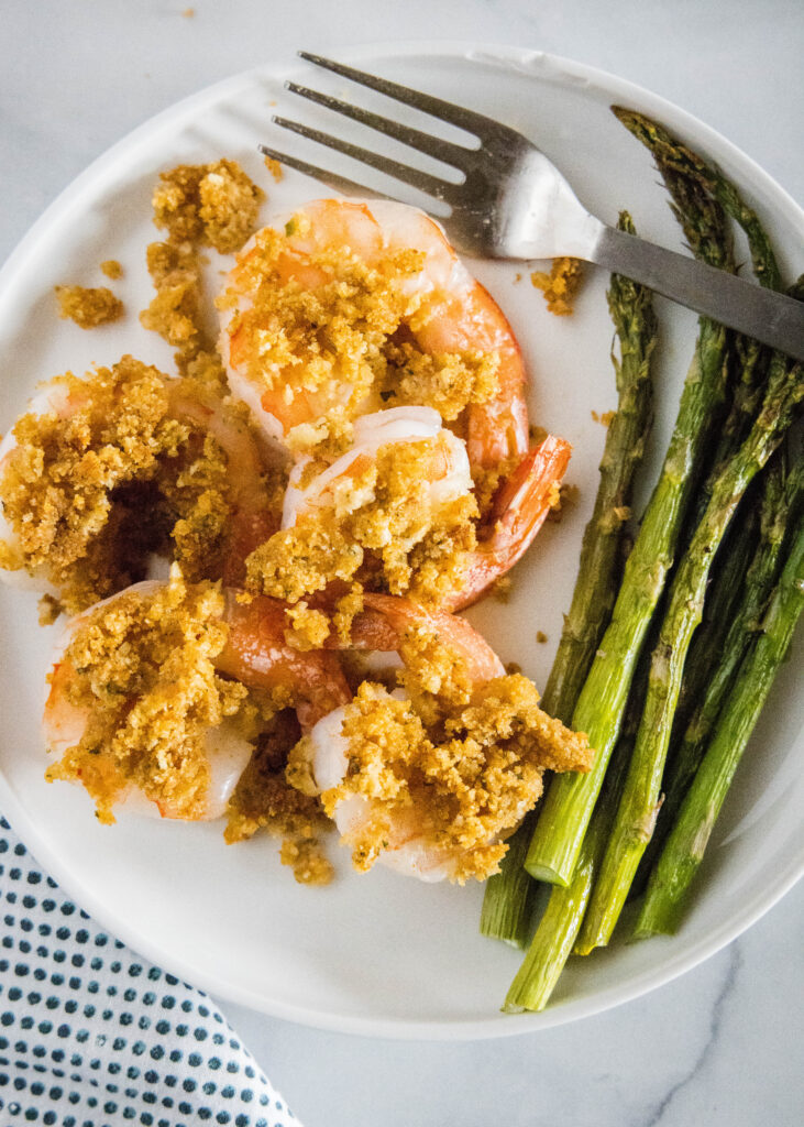 Looking down at a plate of crispy prawns with asparagus