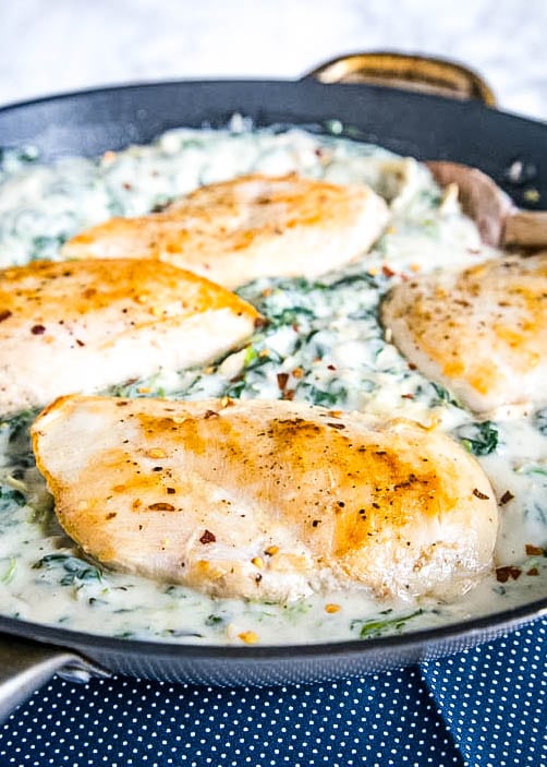 Chicken with spinach and arichokes in a skillet