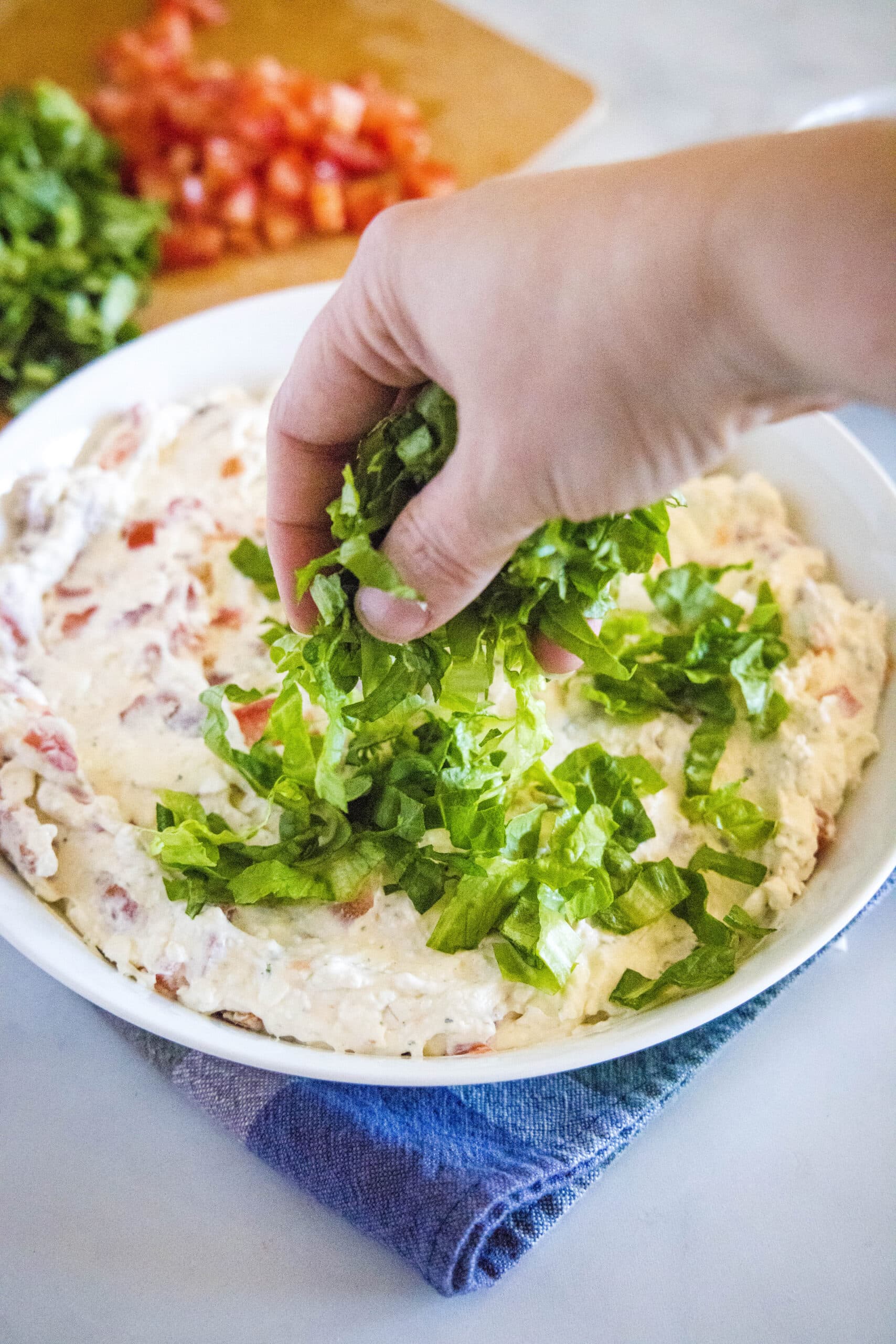 blt dip spread in a bowl topping with lettuce