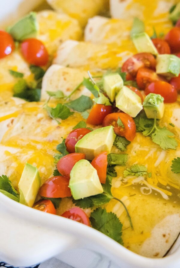 close up breakfast enchiladas with avocado and tomatoes