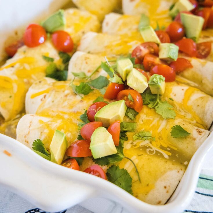 close up breakfast enchiladas with avocado and tomatoes