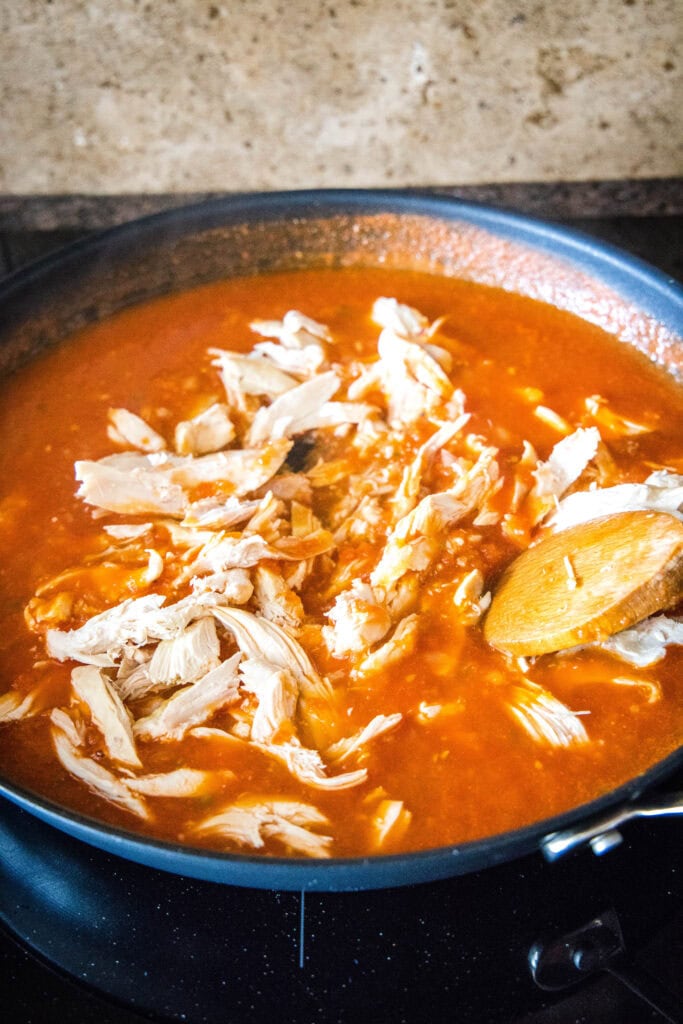 adding chicken to simmering tomato sauce