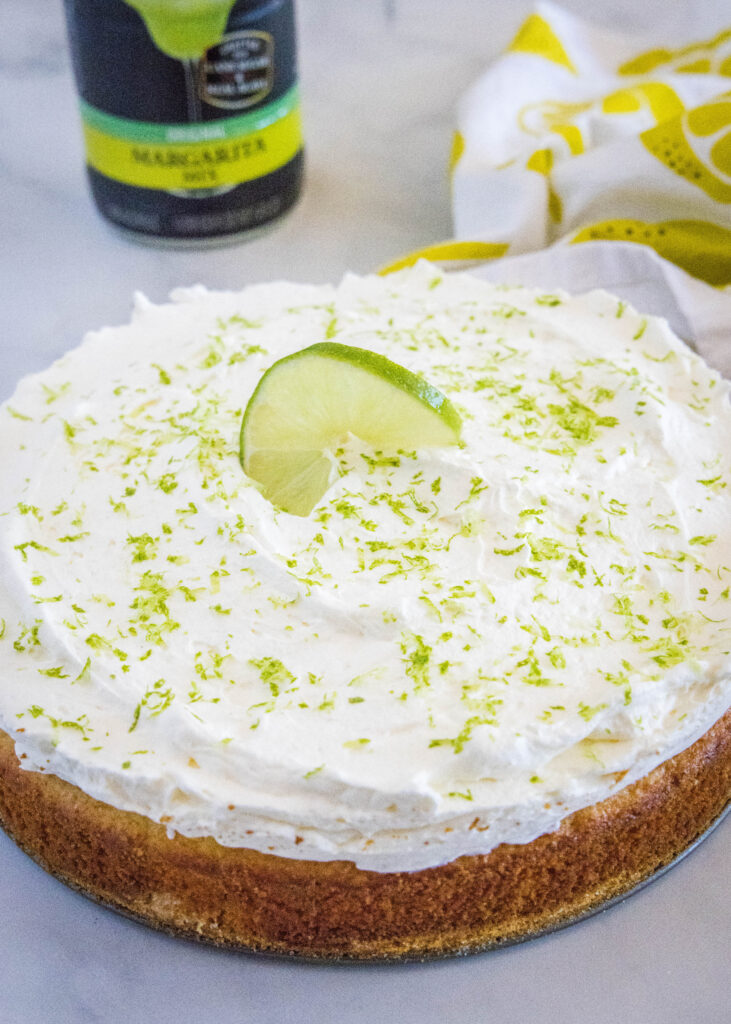 margarita cake topped with lime zest and a slice of lime