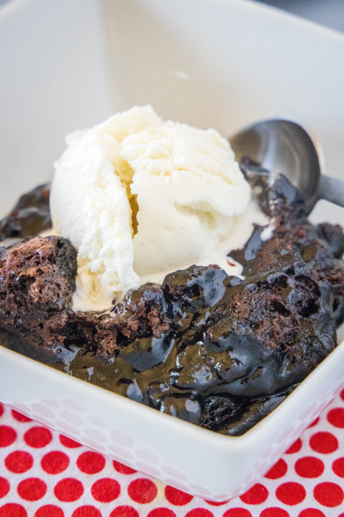 chocolate cobbler in a white bowl with ice cream