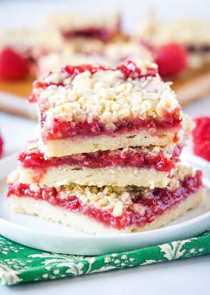 stacked raspberry crumb bars on white plate