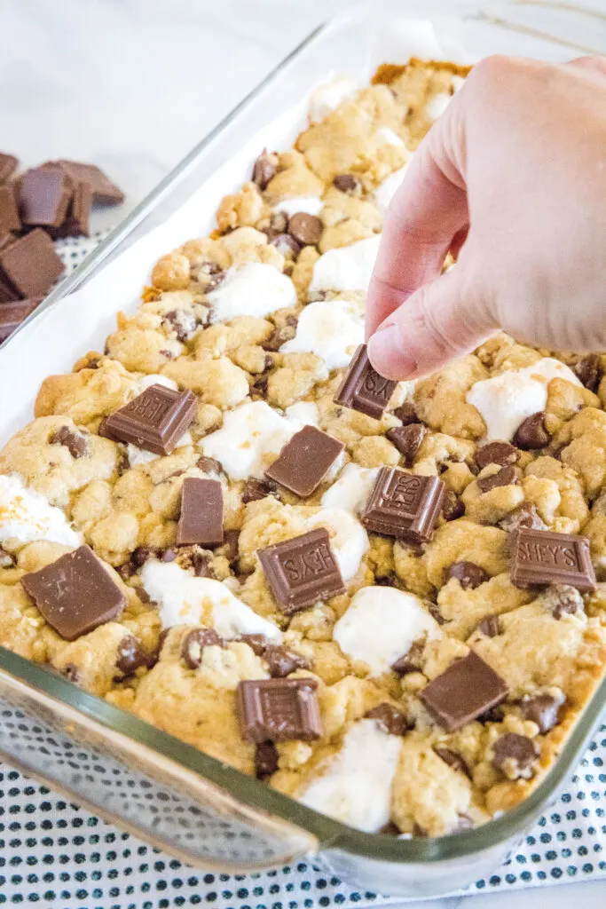 arranging hershey candy bars on top of baked cookie dough