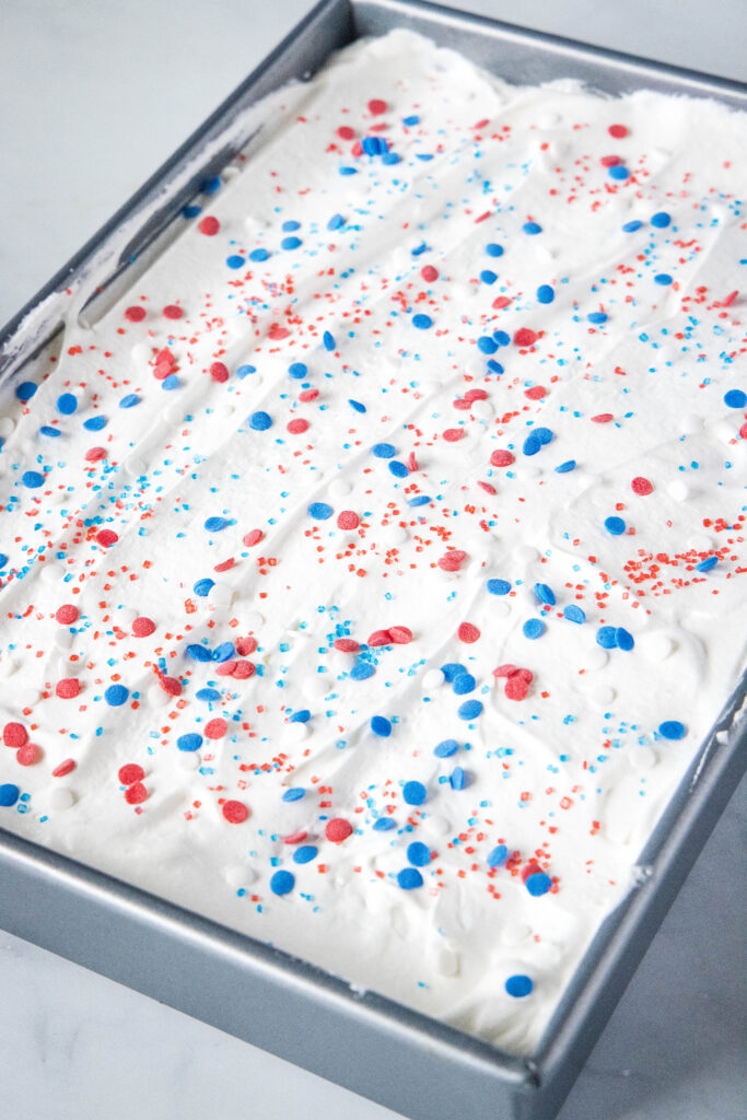 frosted patriotic poke cake with festive sprinkles