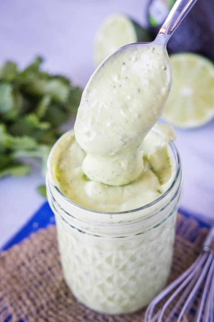 spooining avocado dressing out of a jar