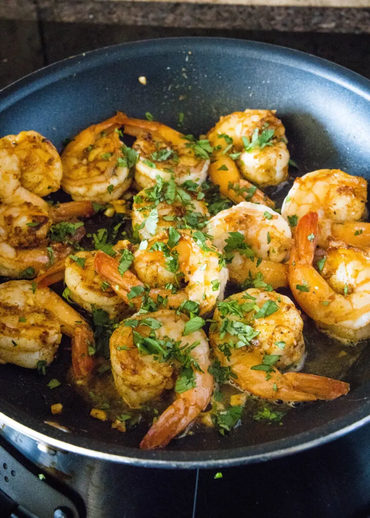 cilantro added to shrimp in skillet