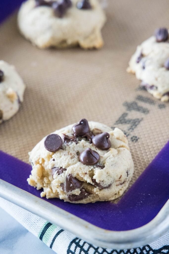 Close up of a few chocolate chip cookies on a baking sheet