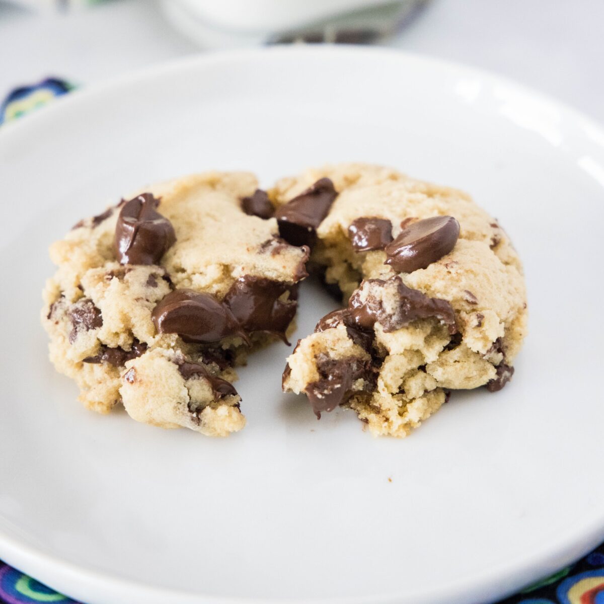 A chocolate chip cookie on a plate, split down the middle