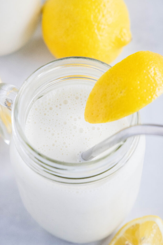 a glass of frosted lemonade with a lemon slice