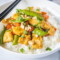 white bowl with spicy chicken stir fry over white rice