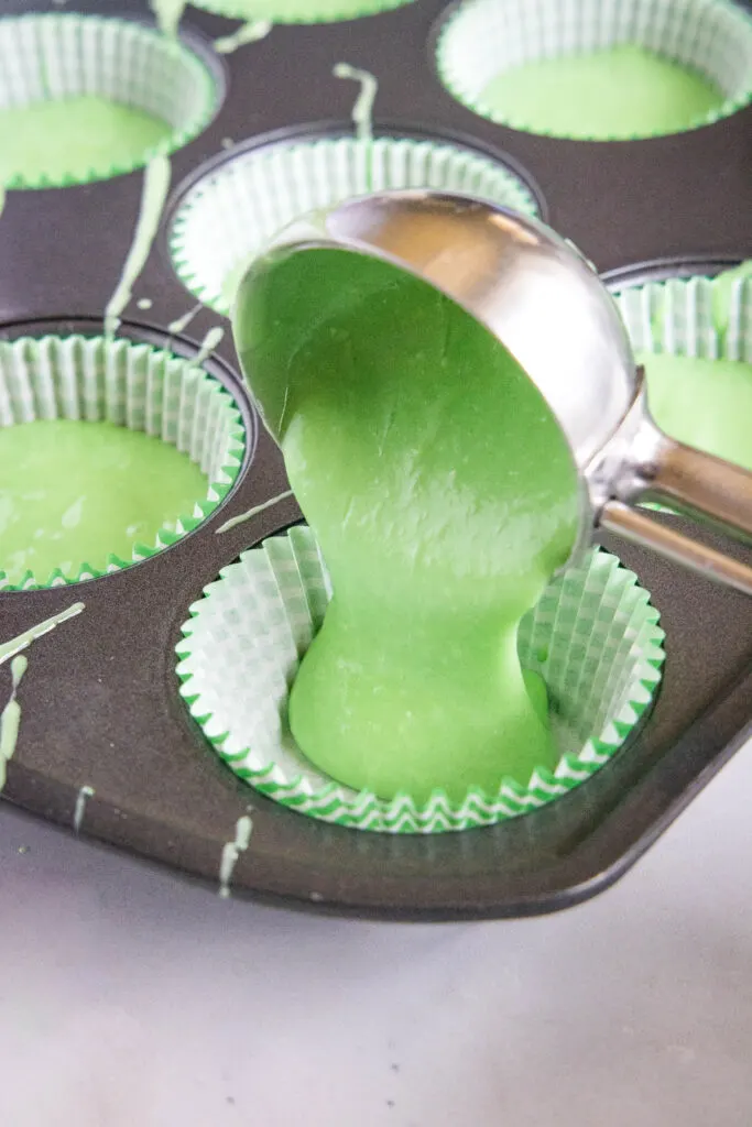 filling muffin tin with cupcake batter