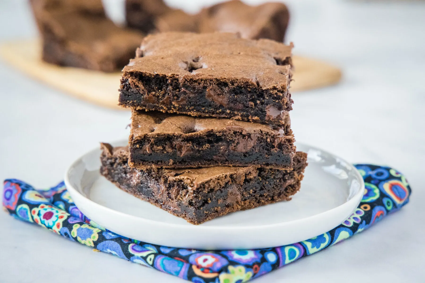 A plate with three brownie squares stacked on each other