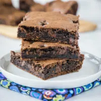 Three squares of brownies stacked on a plate