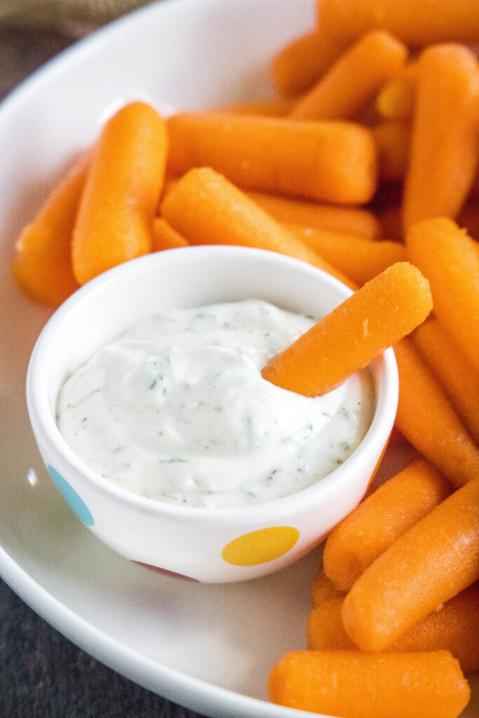 dipping a carrot in ranch dressing