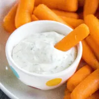 cropped close up dipping a carrot in ranch