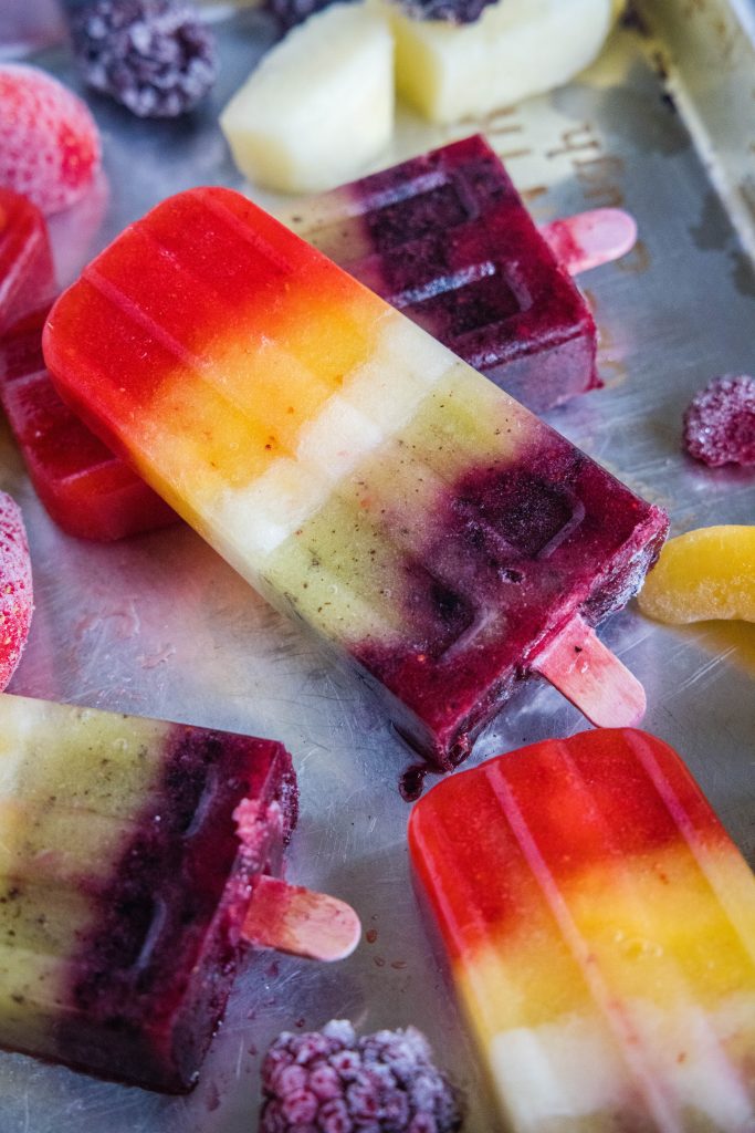 close up rainbow popsicles on a baking tray