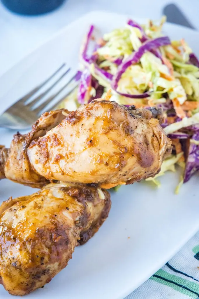 barbecue chicken drumsticks on plate with coleslaw
