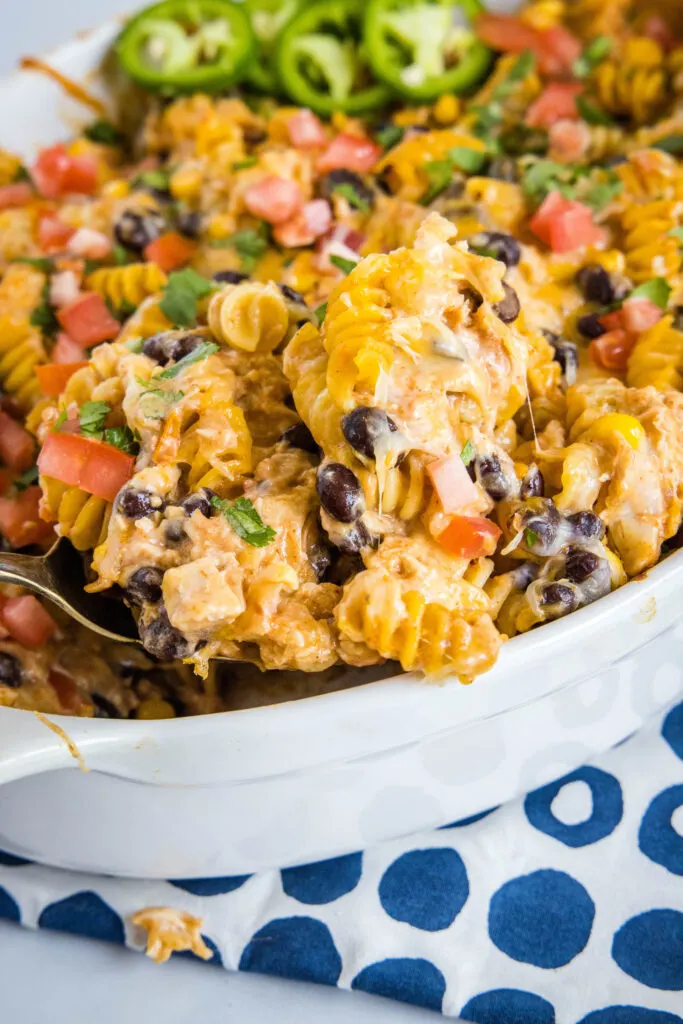 scooping fiesta chicken casserole out of baking dish